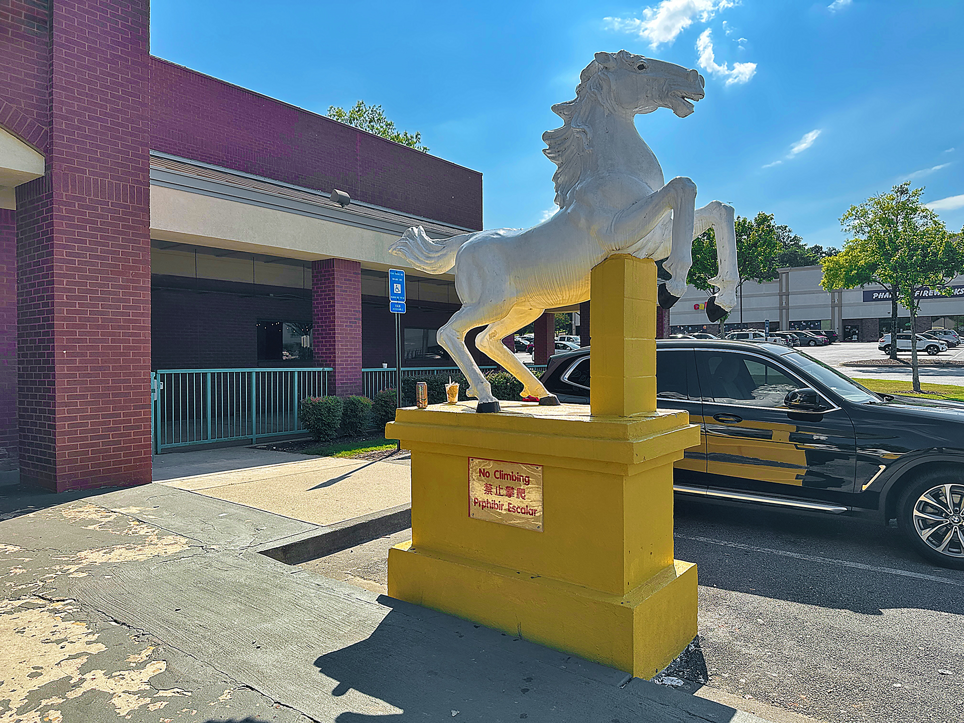 a white horse statue on a yellow pedestal
