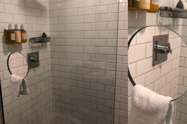 a shower with a round mirror and a towel