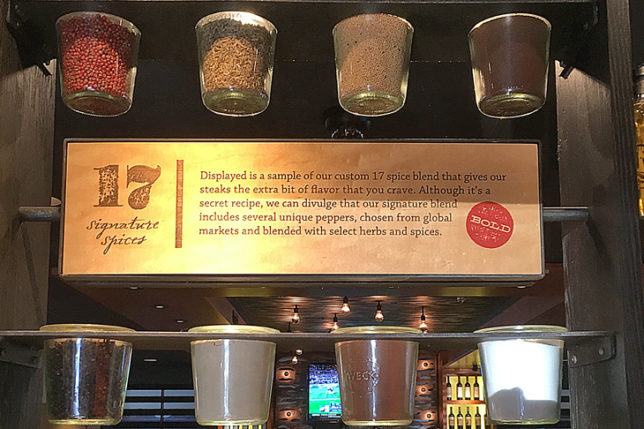 a group of glass jars with spices from a shelf