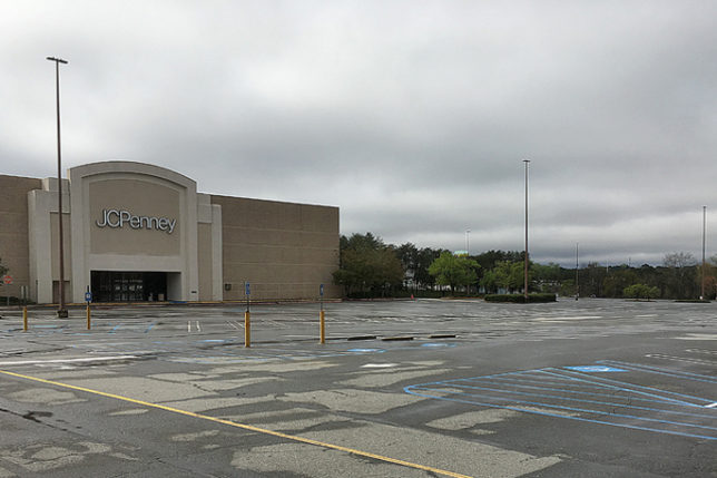 a large parking lot with a building and trees in the background