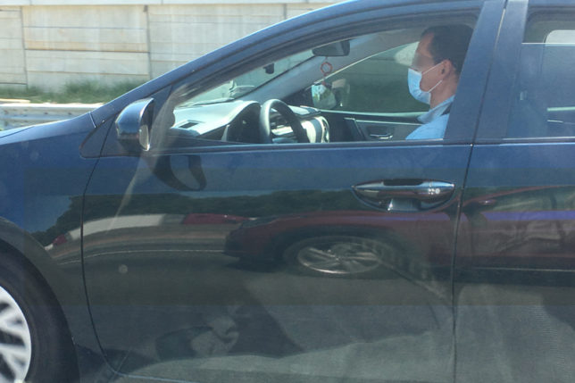 a man in a car wearing a mask