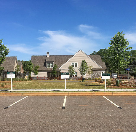 a parking lot with signs in front of a house