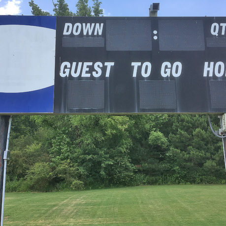 a scoreboard with a blue and white sign with white text