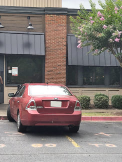 a red car parked in front of a building