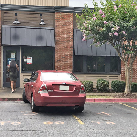 a red car parked in front of a building