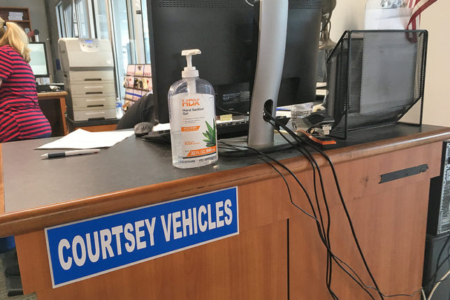 a computer monitor and a bottle of hand sanitizer on a desk