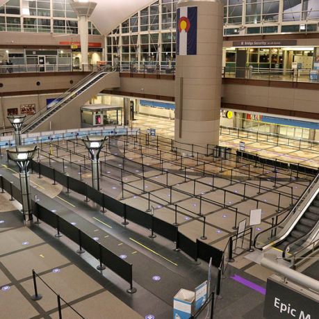 an empty airport with escalators and a large building
