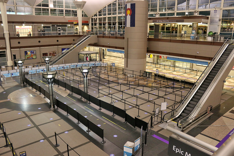 an empty airport with escalators and a large building