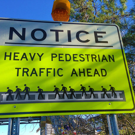 a yellow and white sign with black text and a yellow light