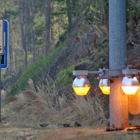 a street sign and a pole with lights