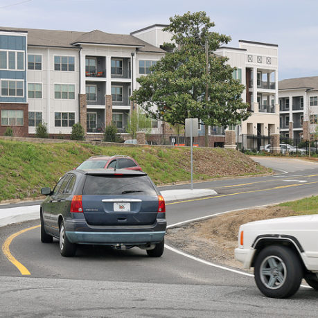 cars on a road with a white truck and a blue car