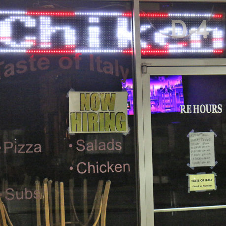 a restaurant with signs on the glass door