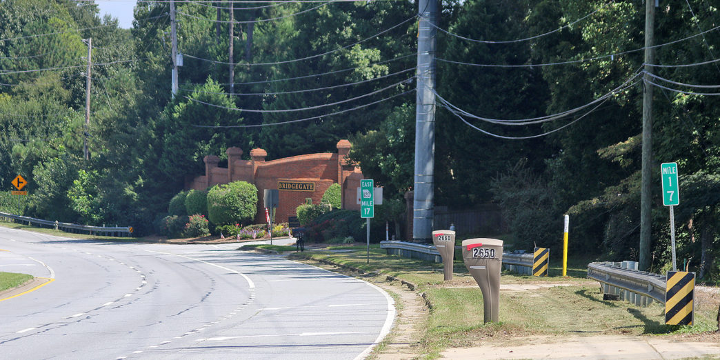 a road with a brick building and trees