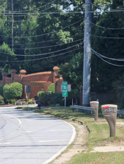 a road with a brick building and trees