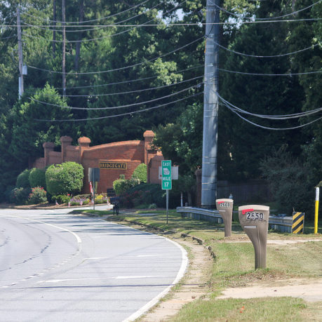 a road with a brick building and trees