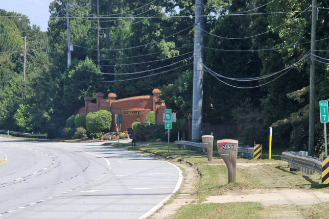 a road with a brick building and trees
