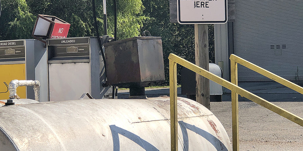 a sign next to a large tank