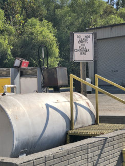 a sign next to a large tank