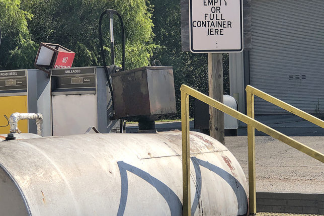 a sign next to a large tank