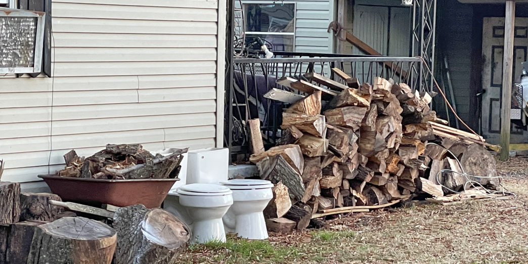 a stack of wood next to a building