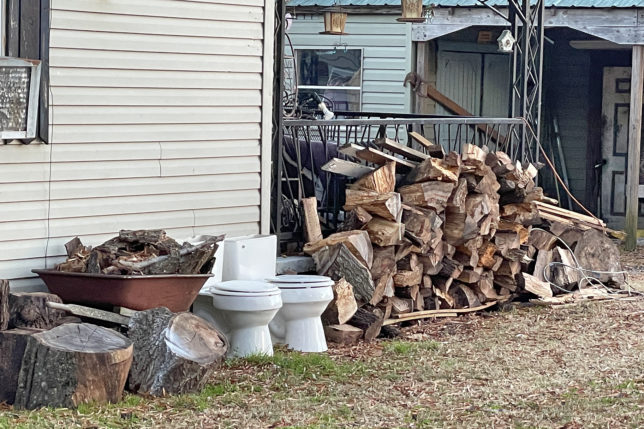 a stack of wood next to a building