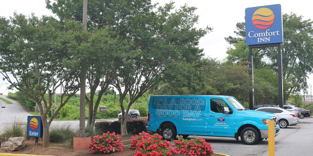 a blue van parked in front of a sign