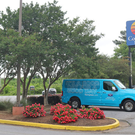 a blue van parked in front of a sign
