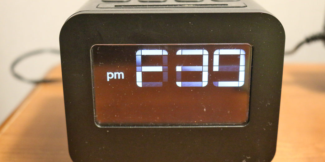 a black digital clock on a wood surface