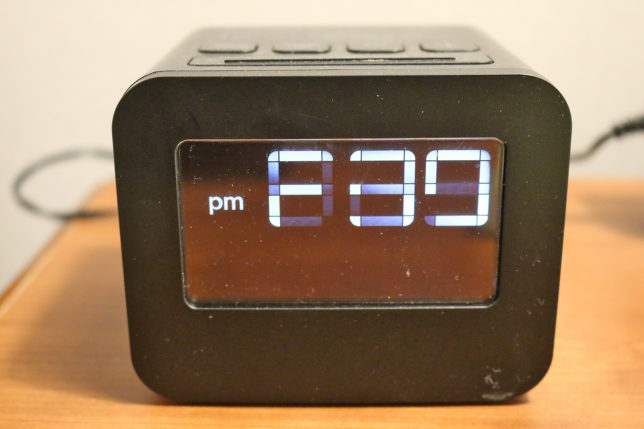 a black digital clock on a wood surface