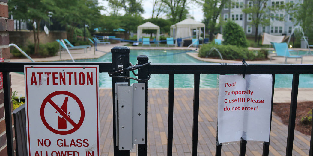 a pool with a sign on the fence