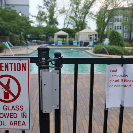 a pool with a sign on the fence