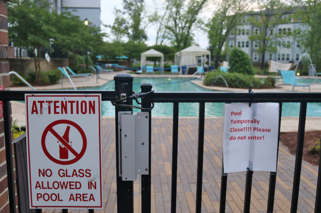 a pool with a sign on the fence