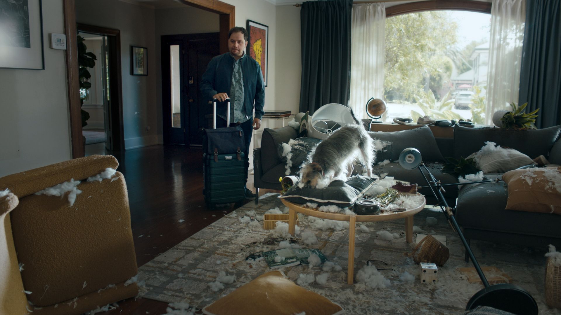 a man standing in a room with a dog on a coffee table