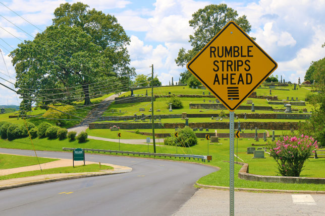 a road sign with grass and trees