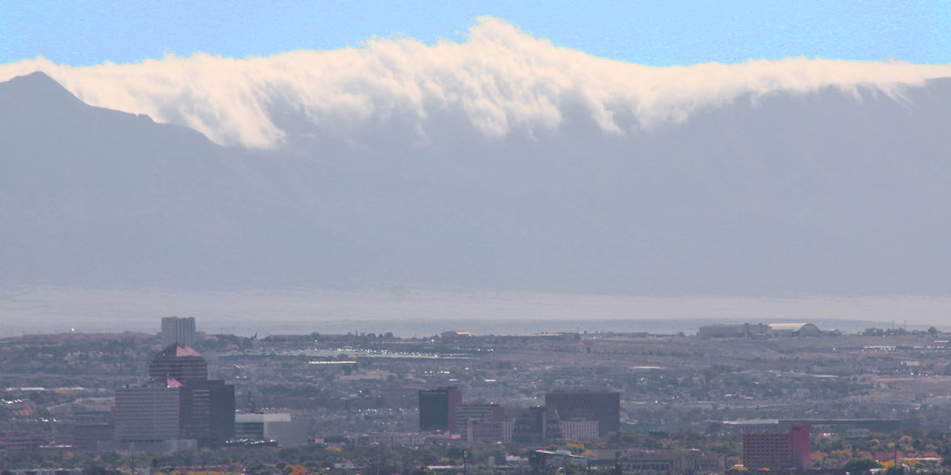 a city with trees and mountains in the background