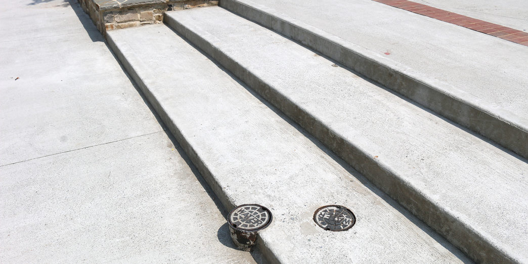a concrete stairs with a drain