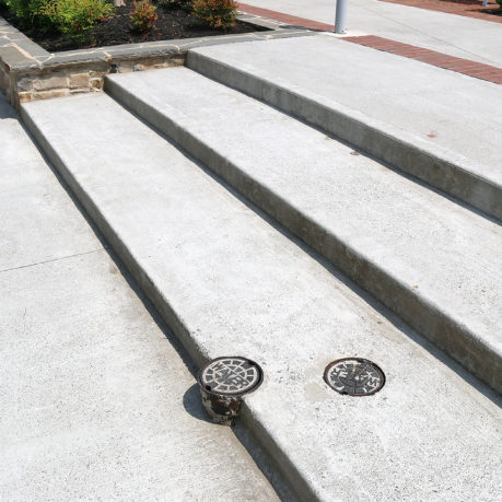a concrete stairs with a drain