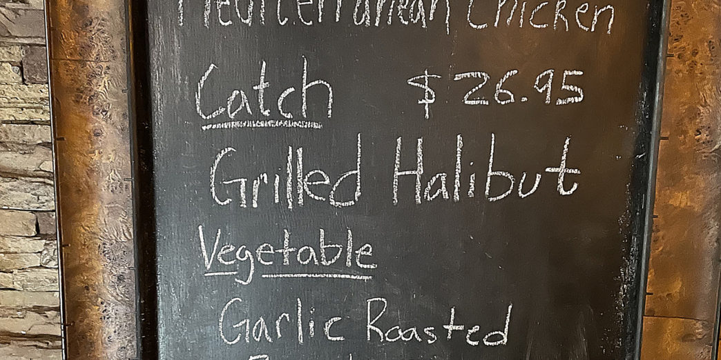 a chalkboard with a price list