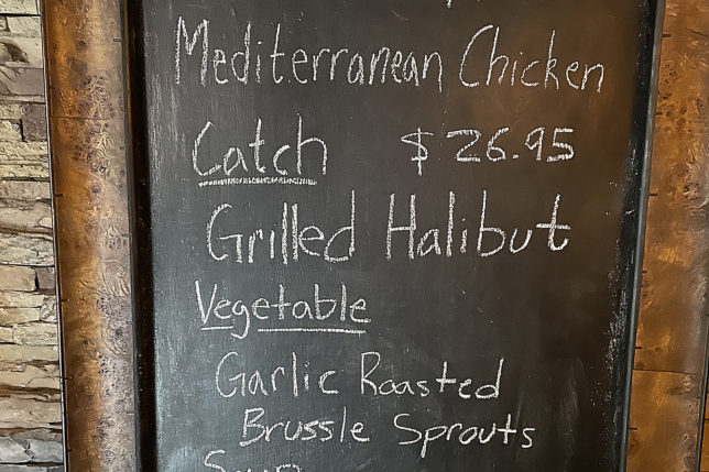 a chalkboard with a price list