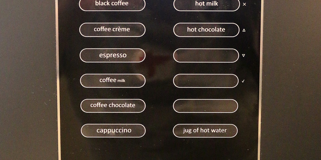 a black vending machine with buttons and buttons
