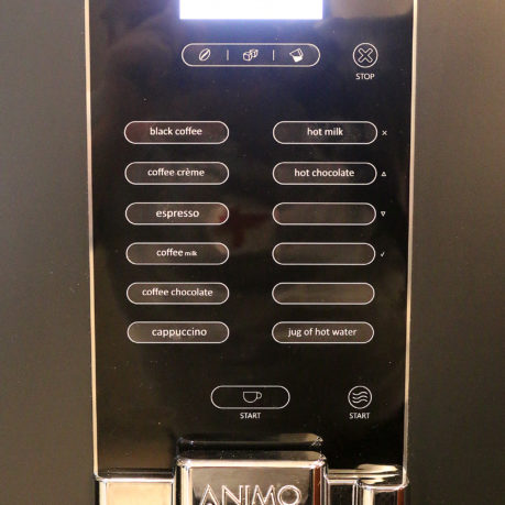 a black vending machine with buttons and buttons