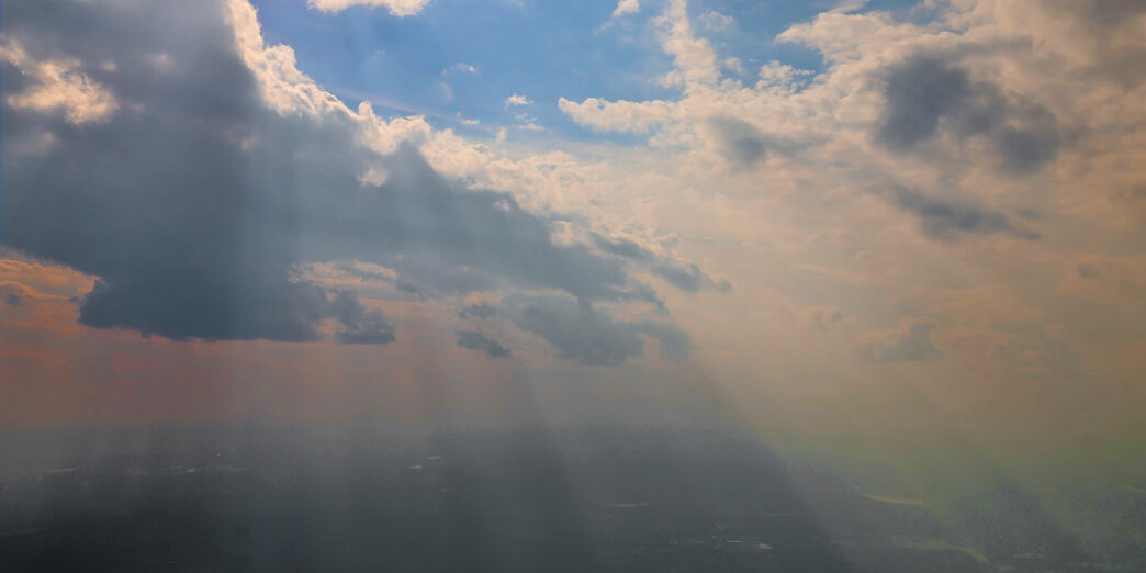 sun shining through clouds in the sky