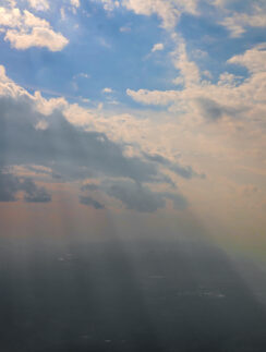 sun shining through clouds in the sky