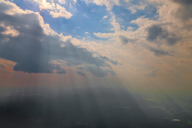 sun shining through clouds in the sky