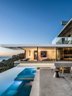a house with a pool and a view of the ocean