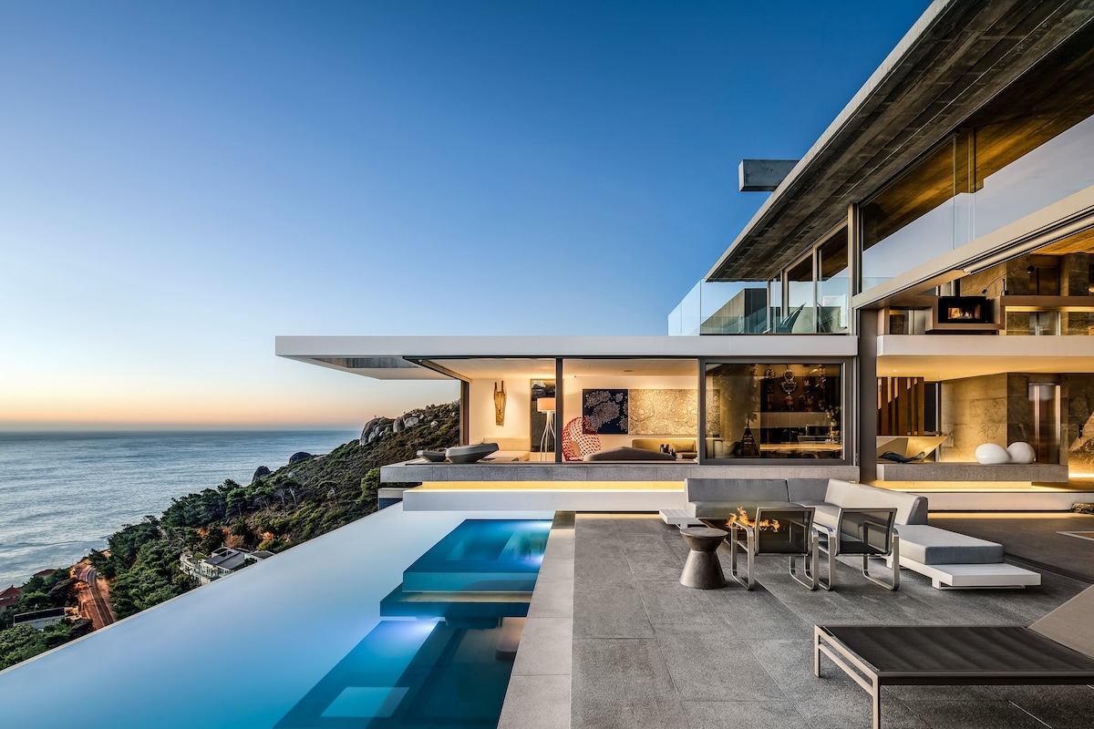 a house with a pool and a view of the ocean
