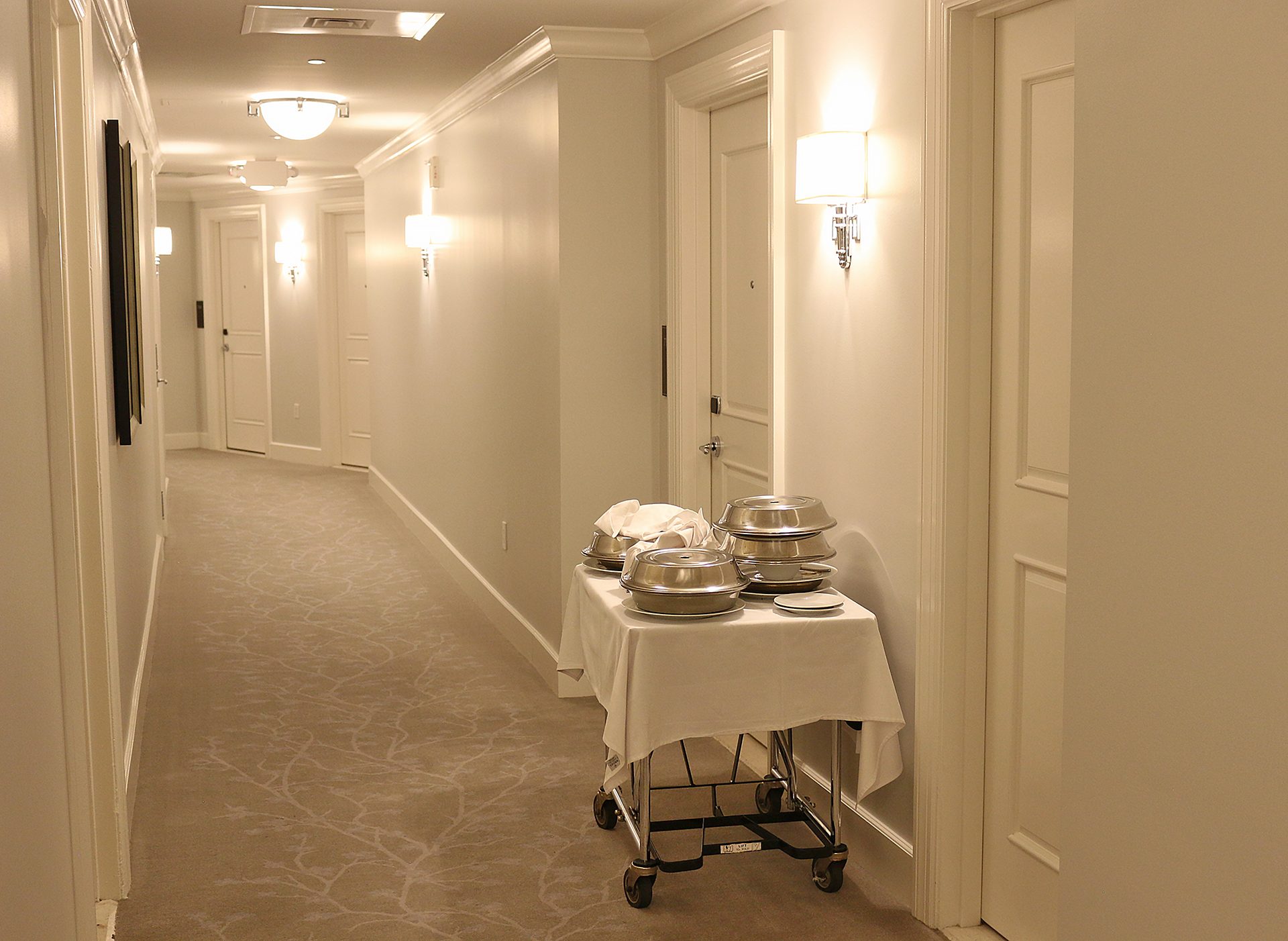 a hotel hallway with a cart with food on it