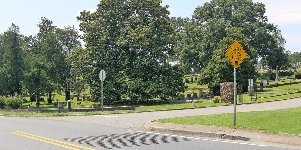 a road with a sign and trees