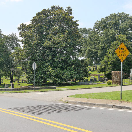 a road with a sign and trees