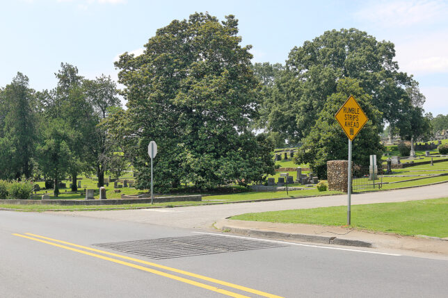 a road with a sign and trees